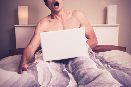 Man masturbating in bed with laptop.